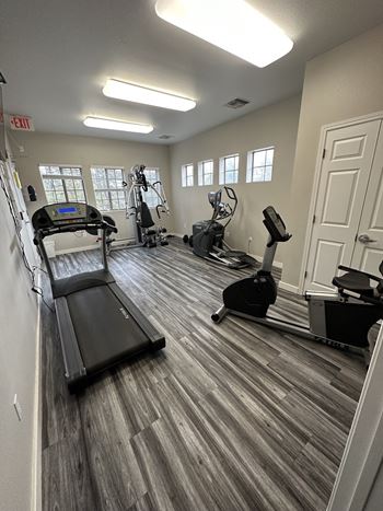 an exercise room with treadmills and ellipticals